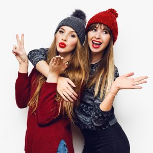 Two young women with winter clothing and long blonde hair