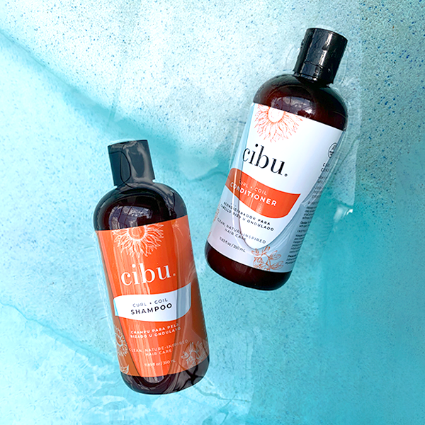 cibu Curl and Coil Shampoo and Conditioner bottles in water